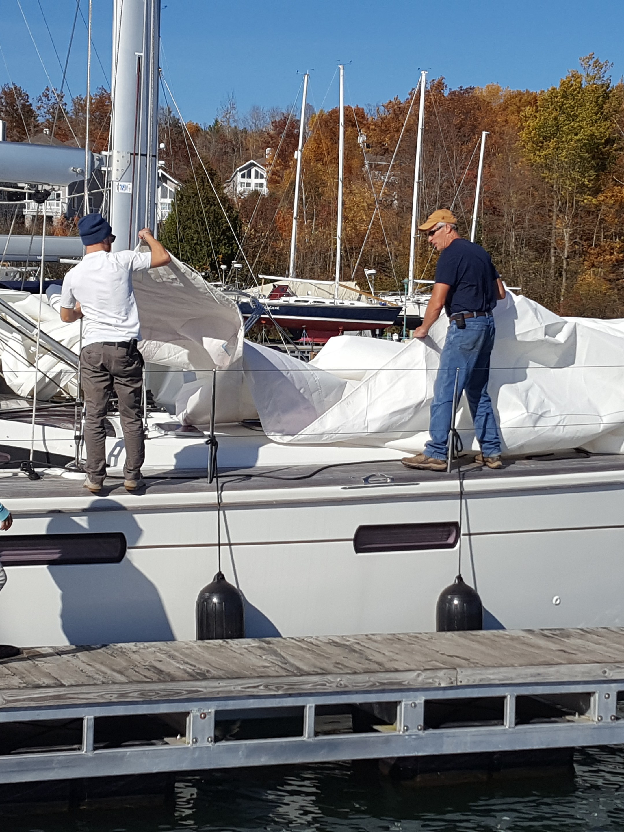 Superior crew taking covering off sailboat