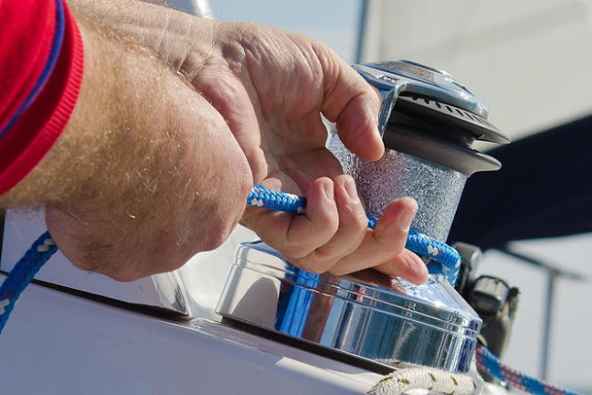 Close up of hands pulling sailing rope