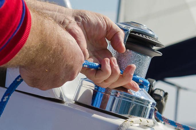 Hands tightening rope on boat