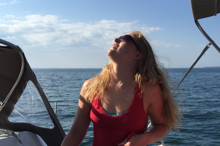 Women looking up at mast on sailboat