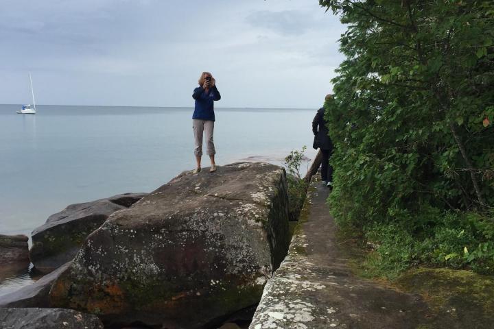 Women standing on lake beach looking out to the water