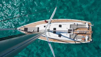Looking down from top of mast to sailboat below sitting in green water