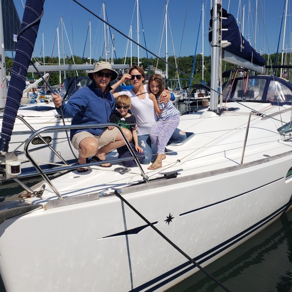 Family sitting together on sailboat during a sunny day
