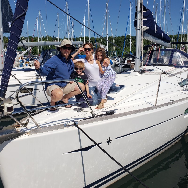 Family sitting together on sailboat during a sunny day
