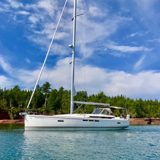 White sailboat sitting on blue lake on sunny day