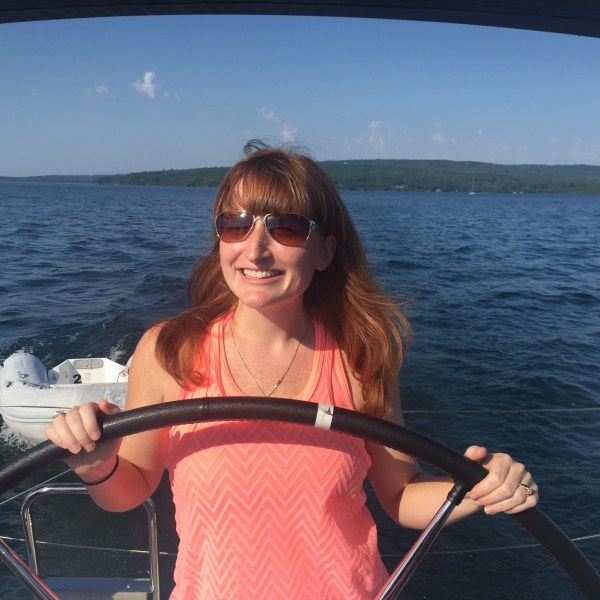 Women steering sailboat and smiling