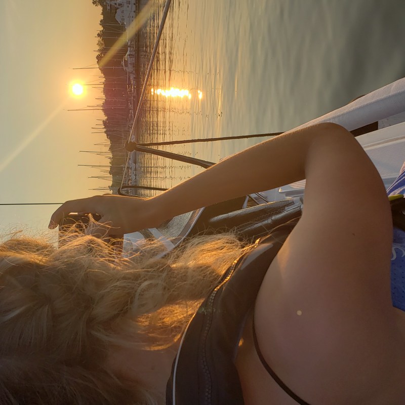 a girl taking a photo of the sunset