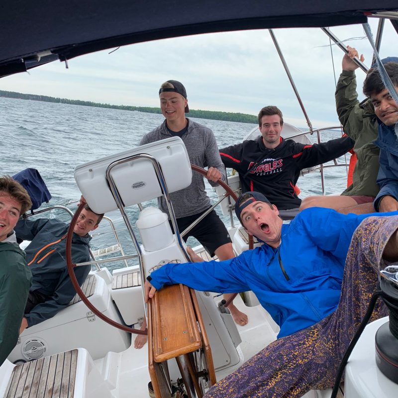 kids on a boat in a body of water sailing