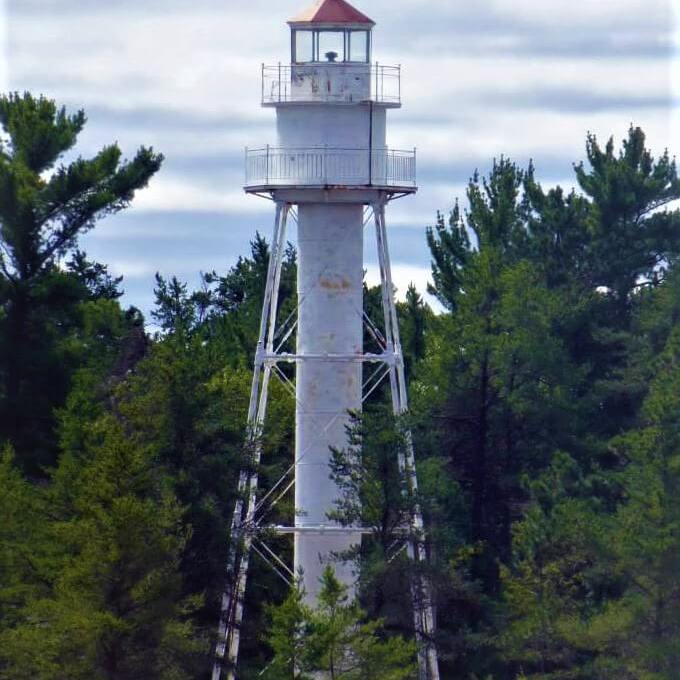 a lighthouse on top of a lush green forest
