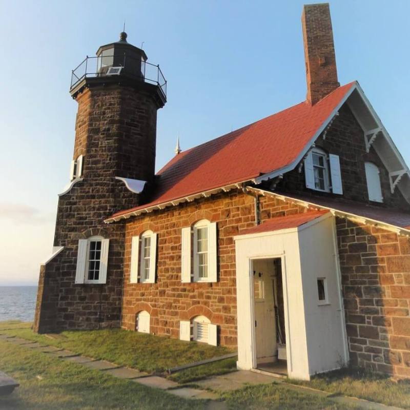 a large brick building with a ligthouse in front of a house