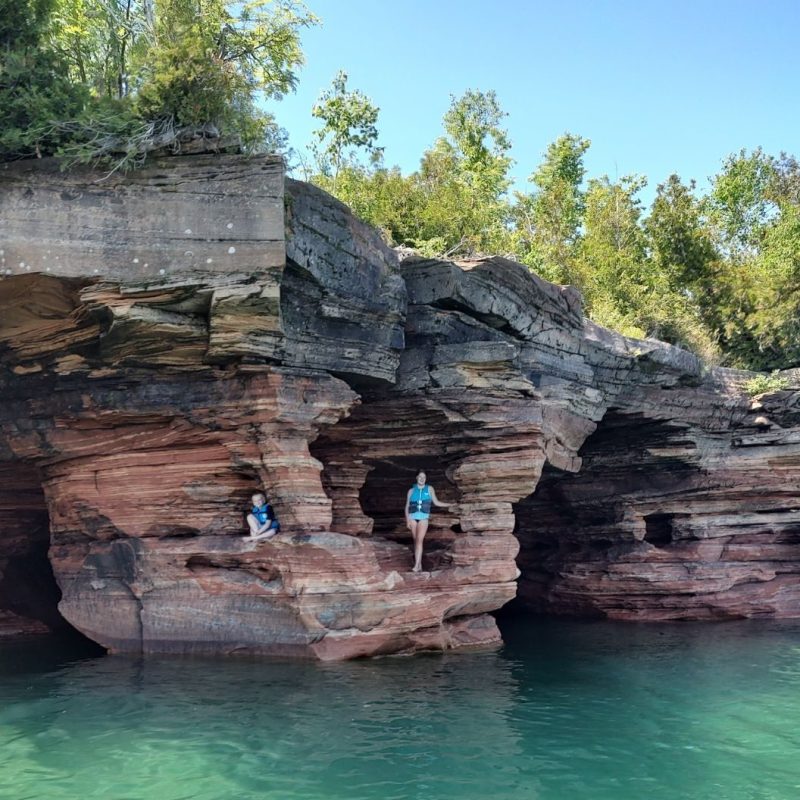 a pool of water in front of a large rock