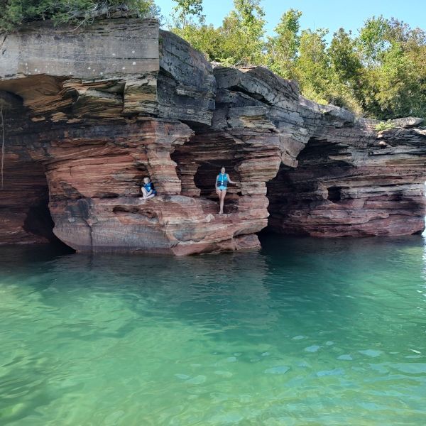 a pool of water in front of a large rock