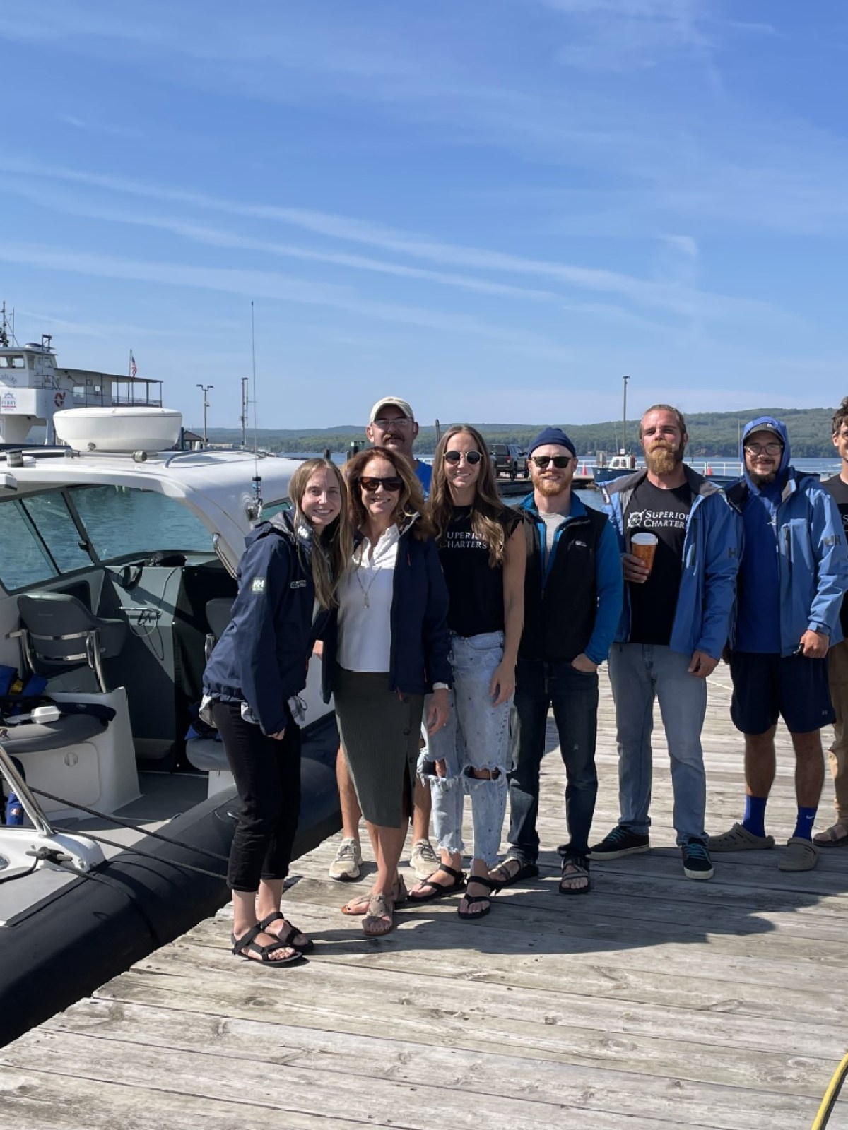 a group of people standing on a boat posing for the camera