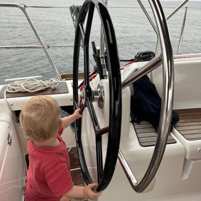 a little girl standing next to a body of water