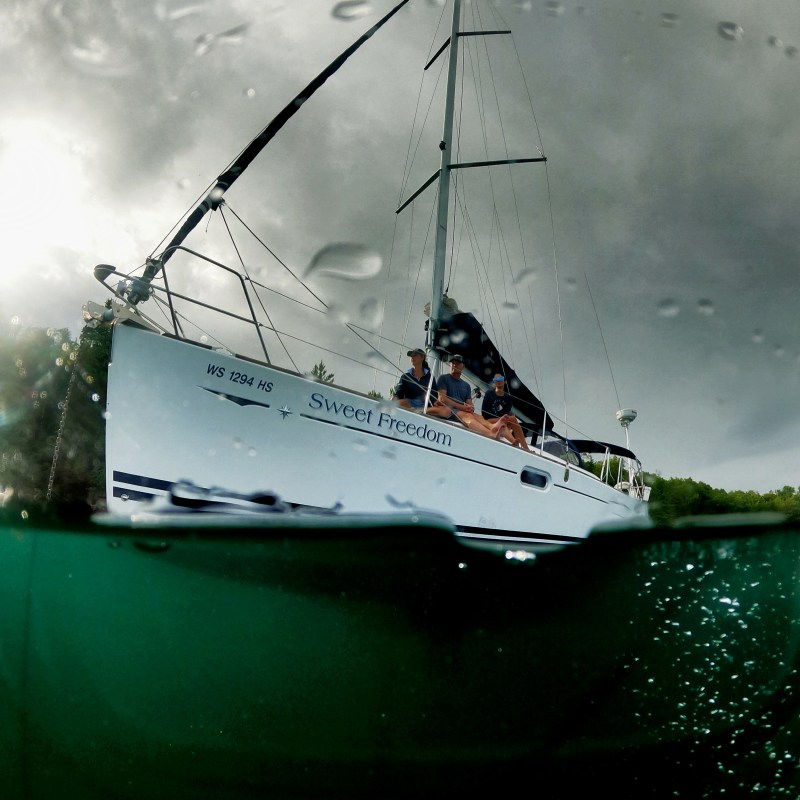 Sailboat on water with overcast sky, partly submerged perspective.